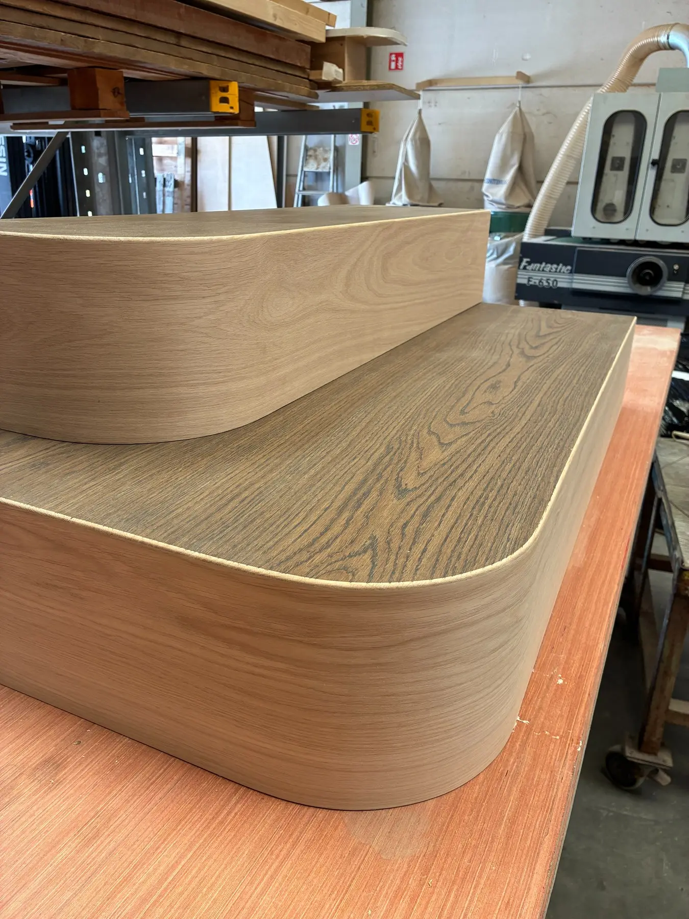 Gebogen houten trede in het atelier, tijdens de productie