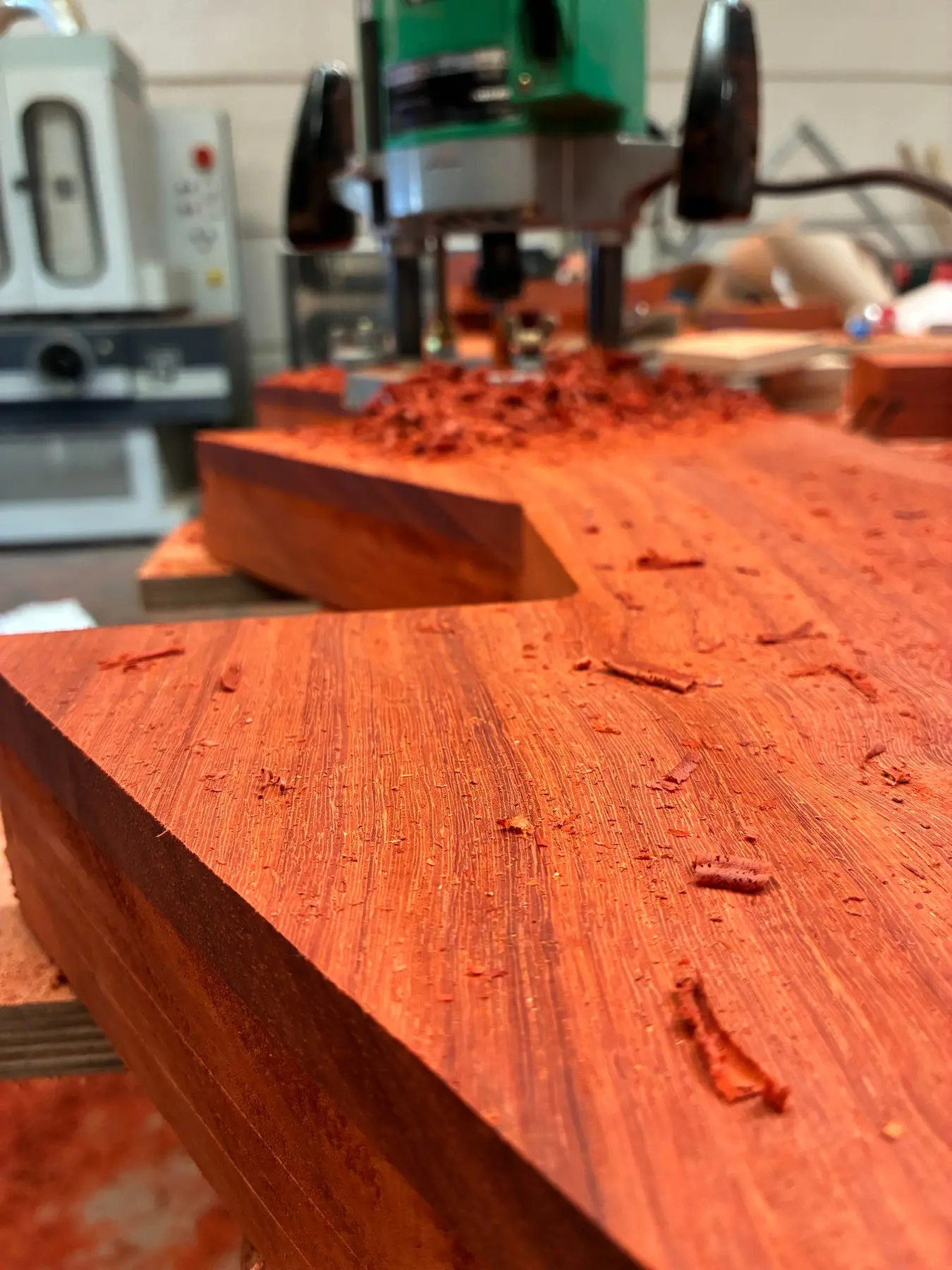Wooden stair tread in red-brown hardwood being machined in the workshop