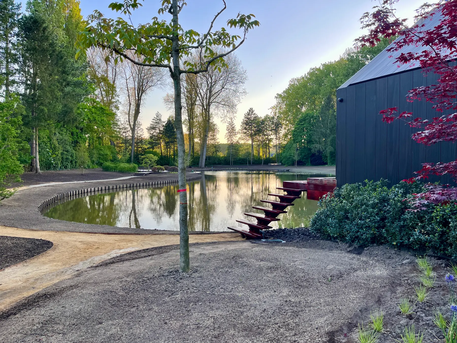 Buitentrap naast een vijver in een aangelegde tuin