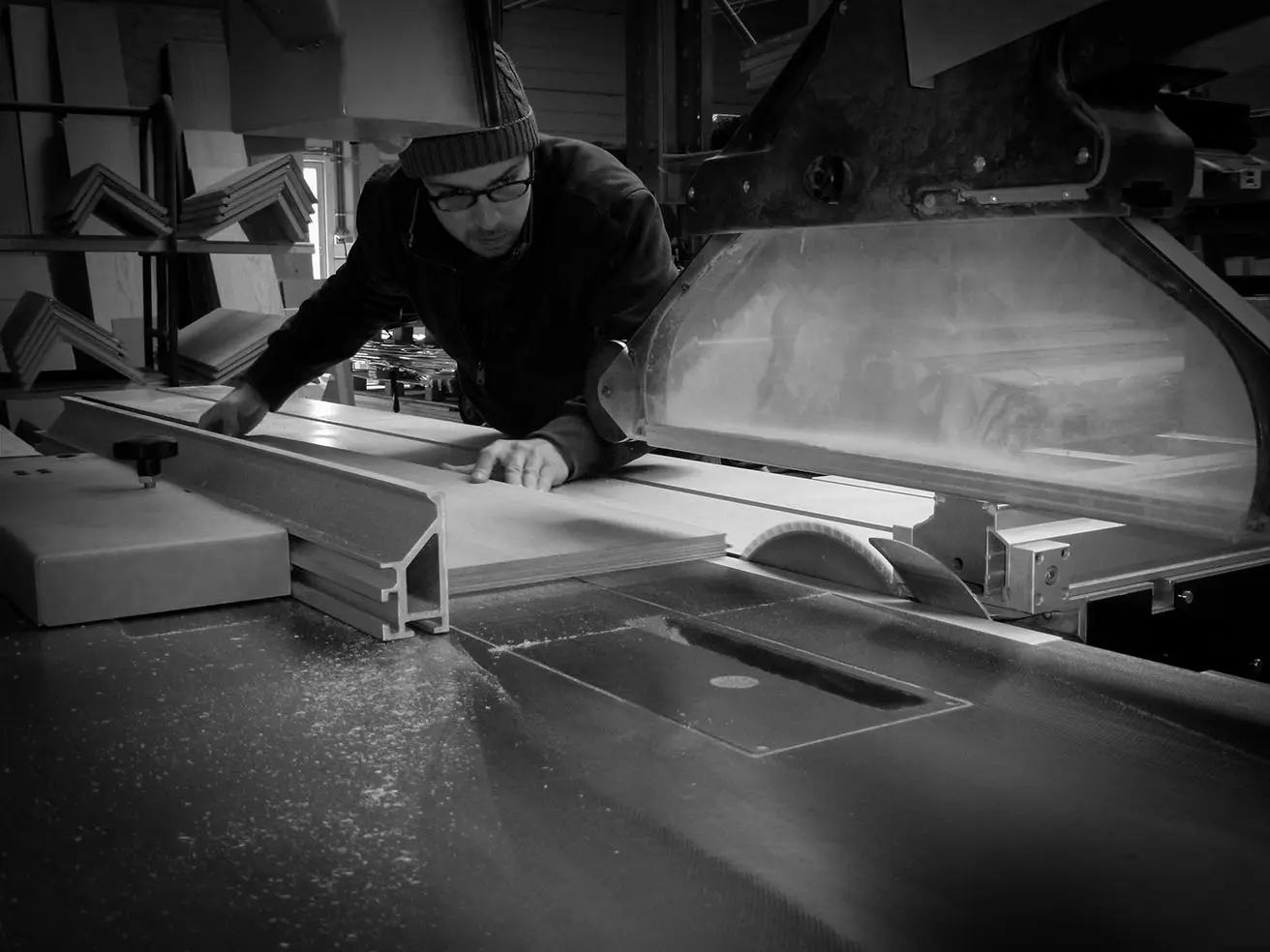 Vakman zaagt een houten trapplank op maat in het atelier